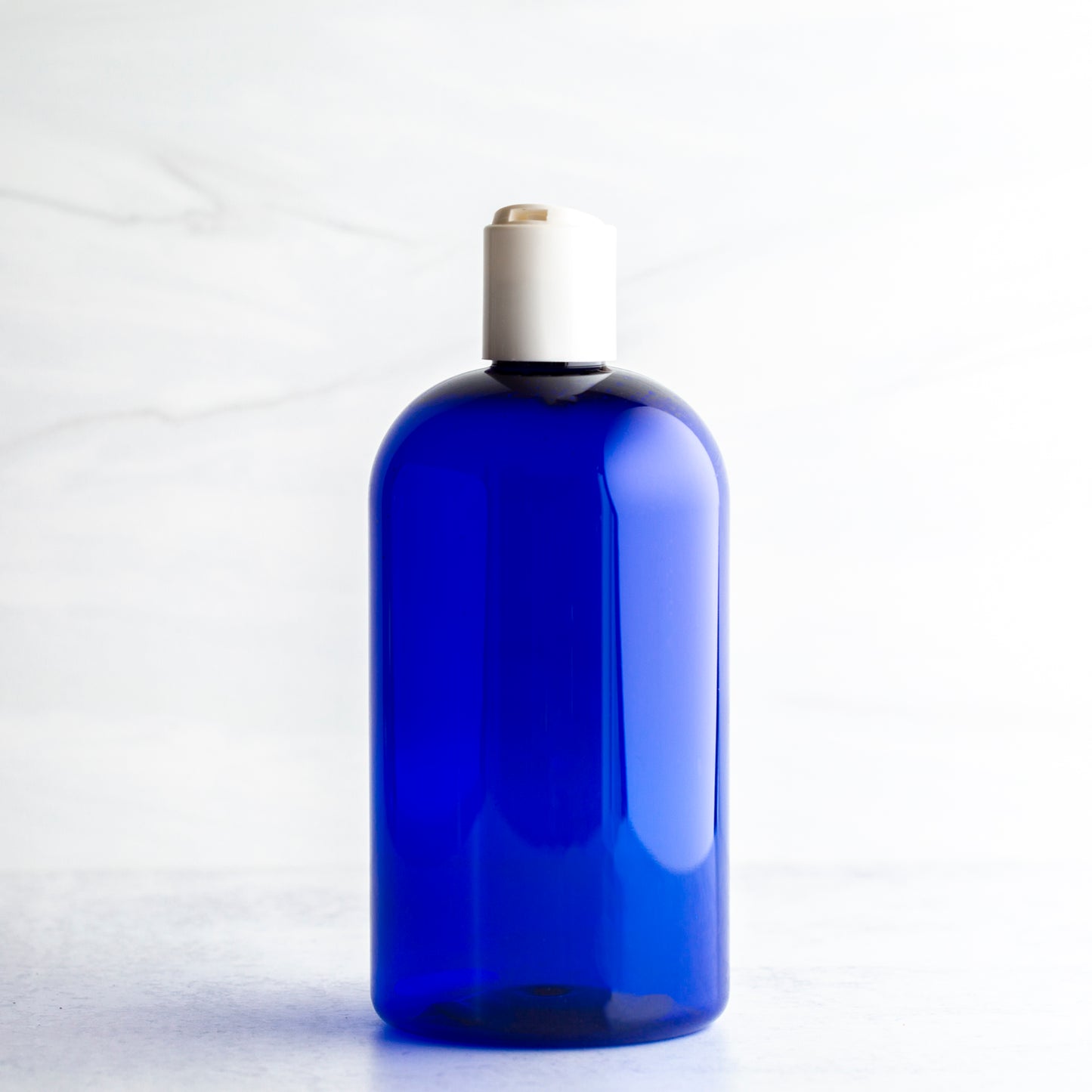 16 oz Blue Boston Round Bottle with 24-410 White Disc Cap