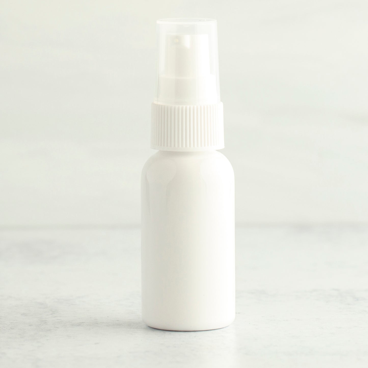 1 oz White PET Boston Round Bottle with 20-410 White Treatment Pump