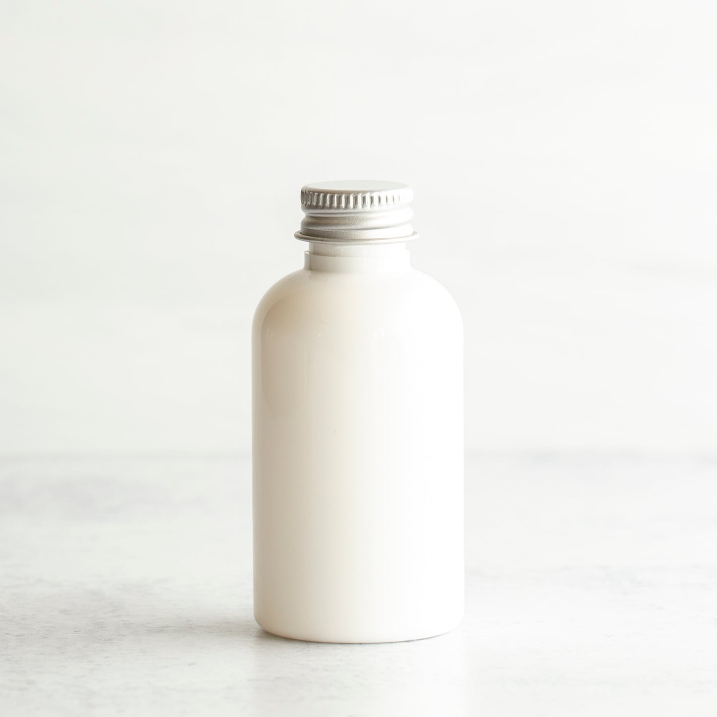 2 oz White PET Boston Round Bottle with 20-410 Aluminum Cap