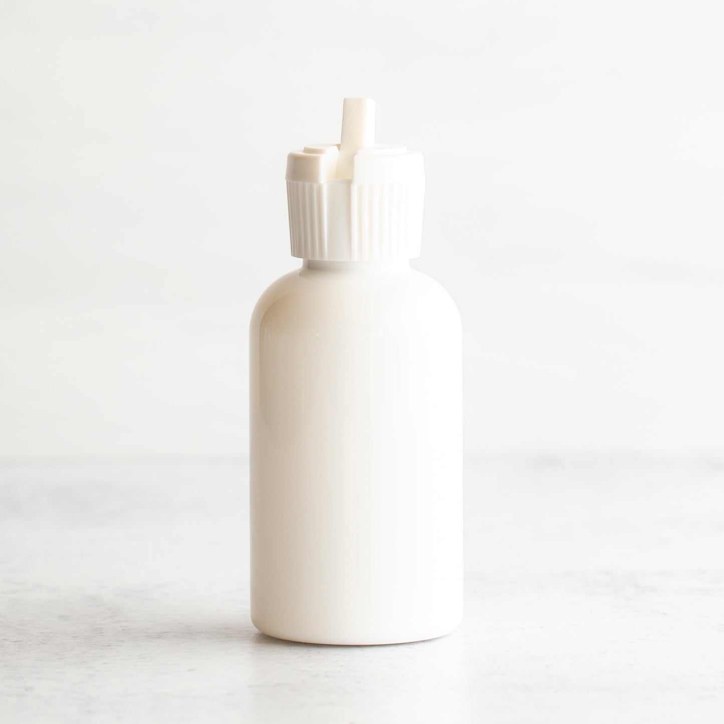 2 oz White PET Boston Round Bottle with 20-410 White Turret Cap