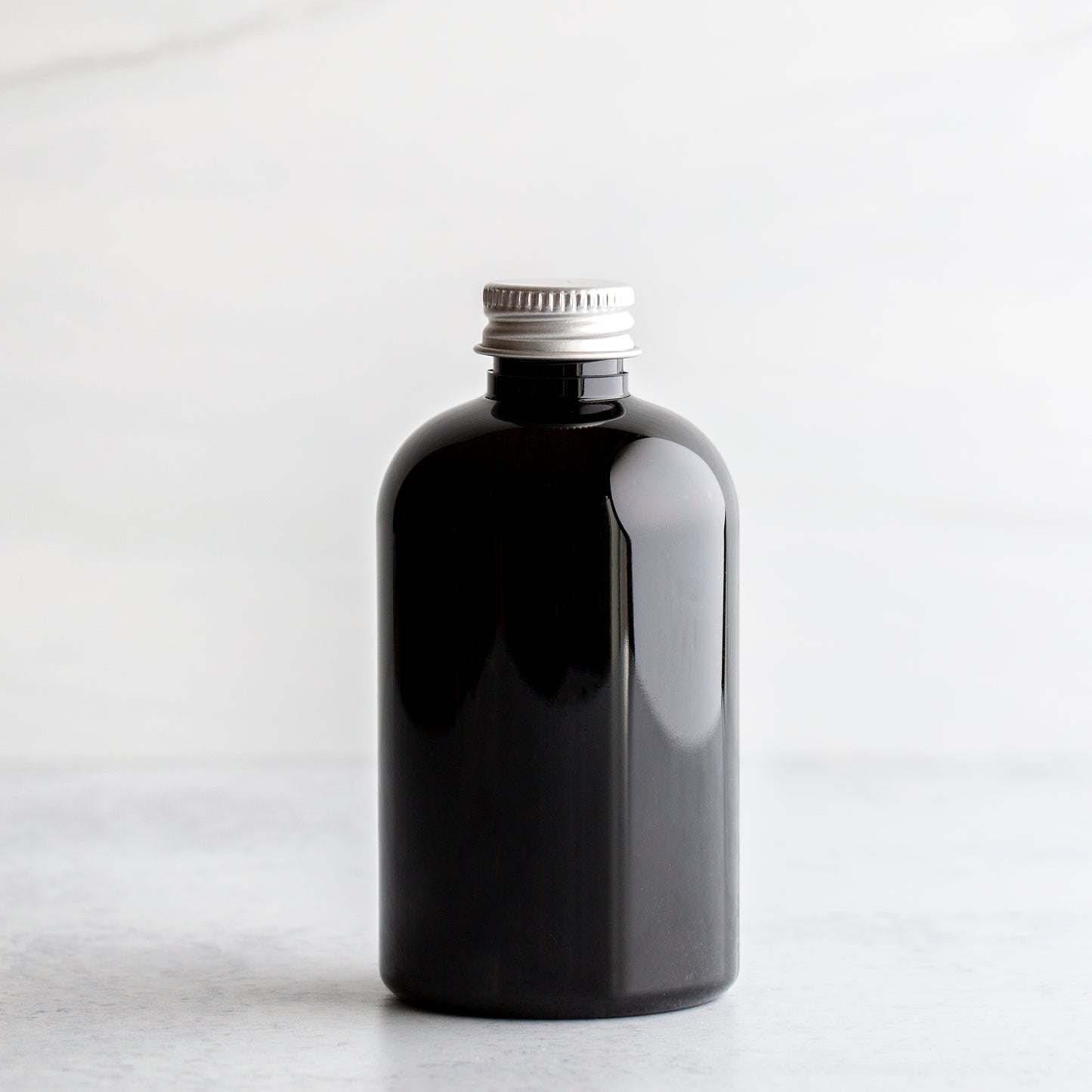 4 oz Black PET Boston Round Bottle with 20-410 Aluminum Cap