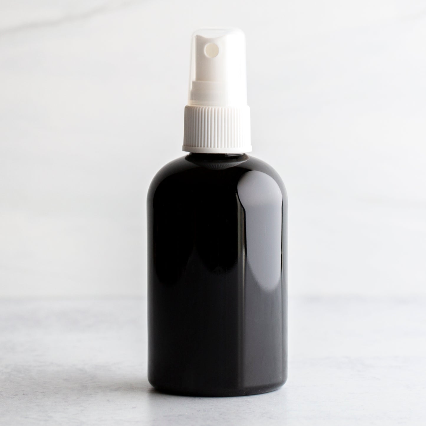 4 oz Black PET Boston Round Bottle with 20-410 White Fine Mist Sprayer