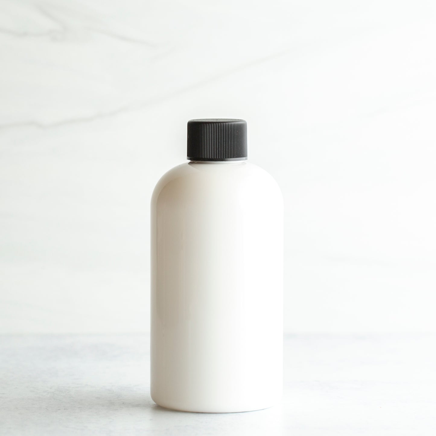 8 oz White PET Boston Round Bottle with 24-410 Black Ribbed Cap