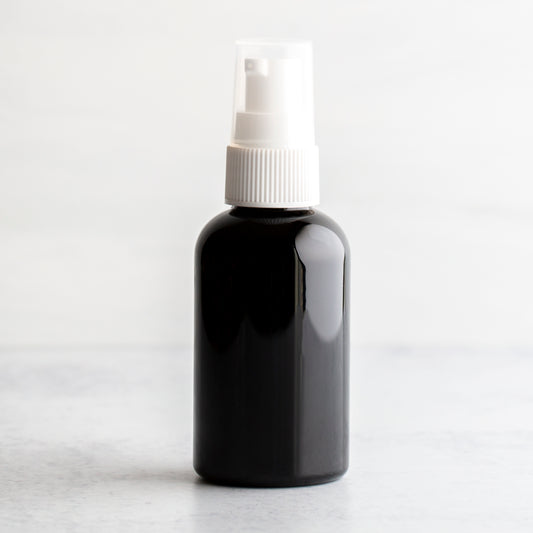 2 oz Black PET Boston Round Bottle with 20-410 White Treatment Pump