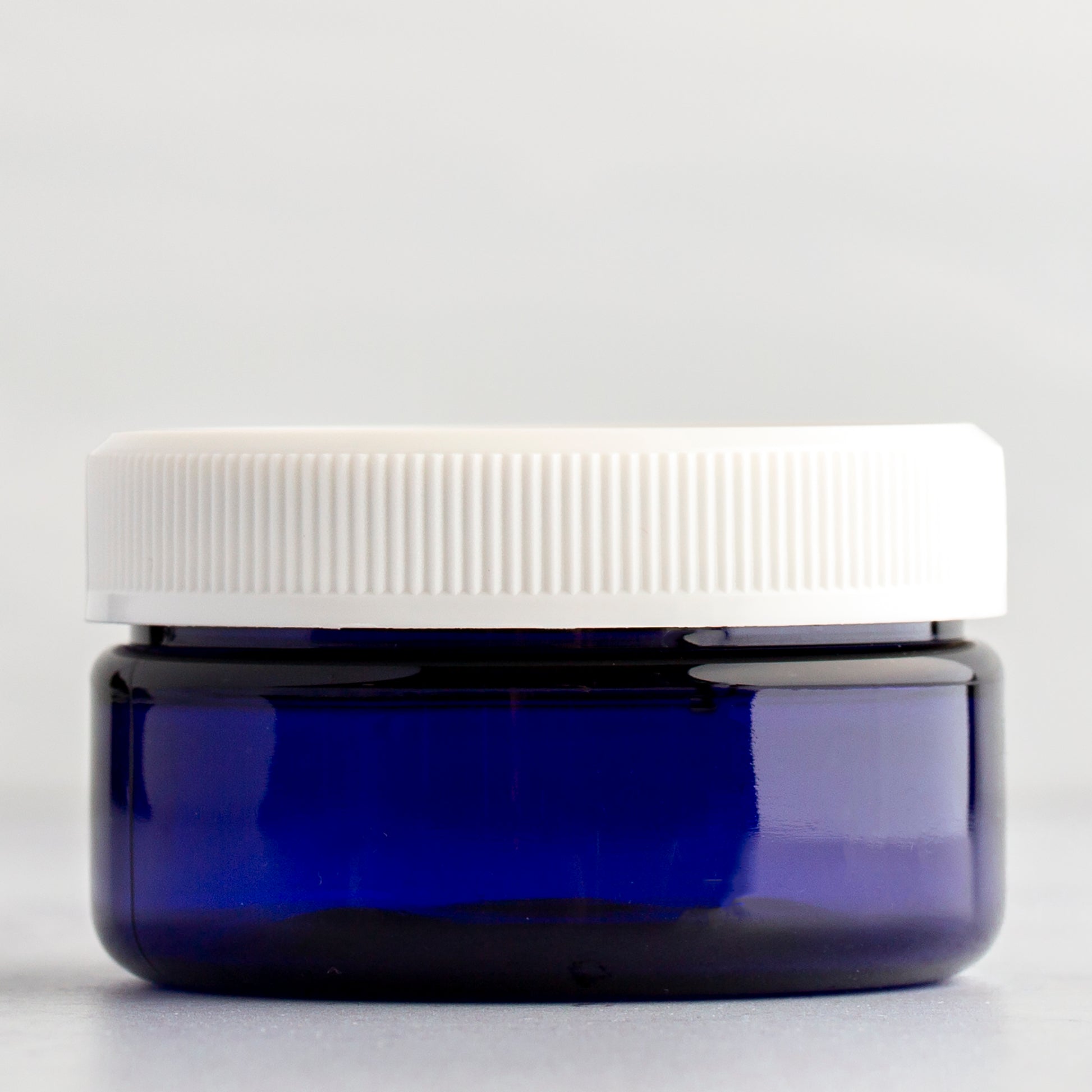 2 oz Blue Shallow Plastic Jar with White Ribbed Cap