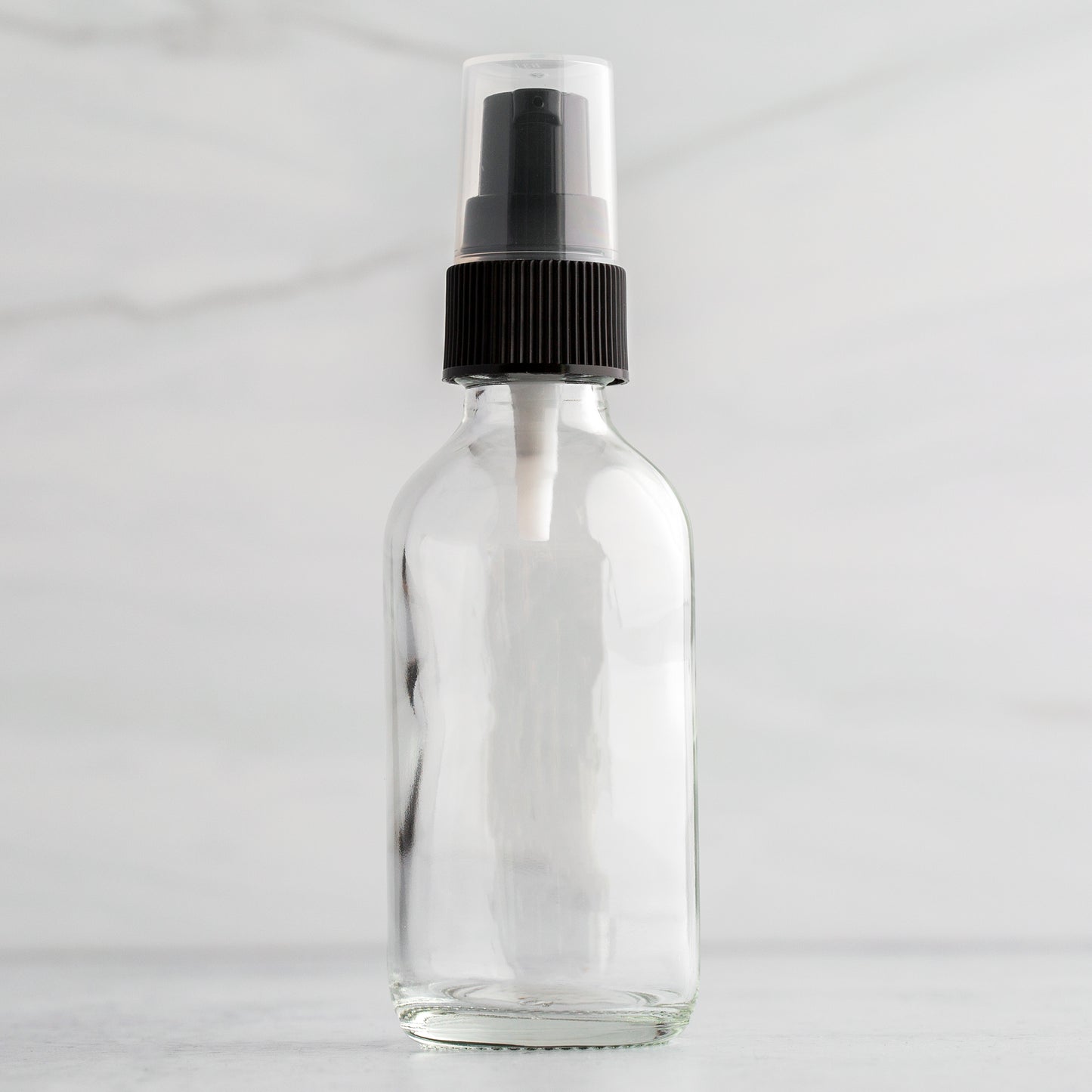 2 oz Clear Glass Bottle with Black Treatment Pump