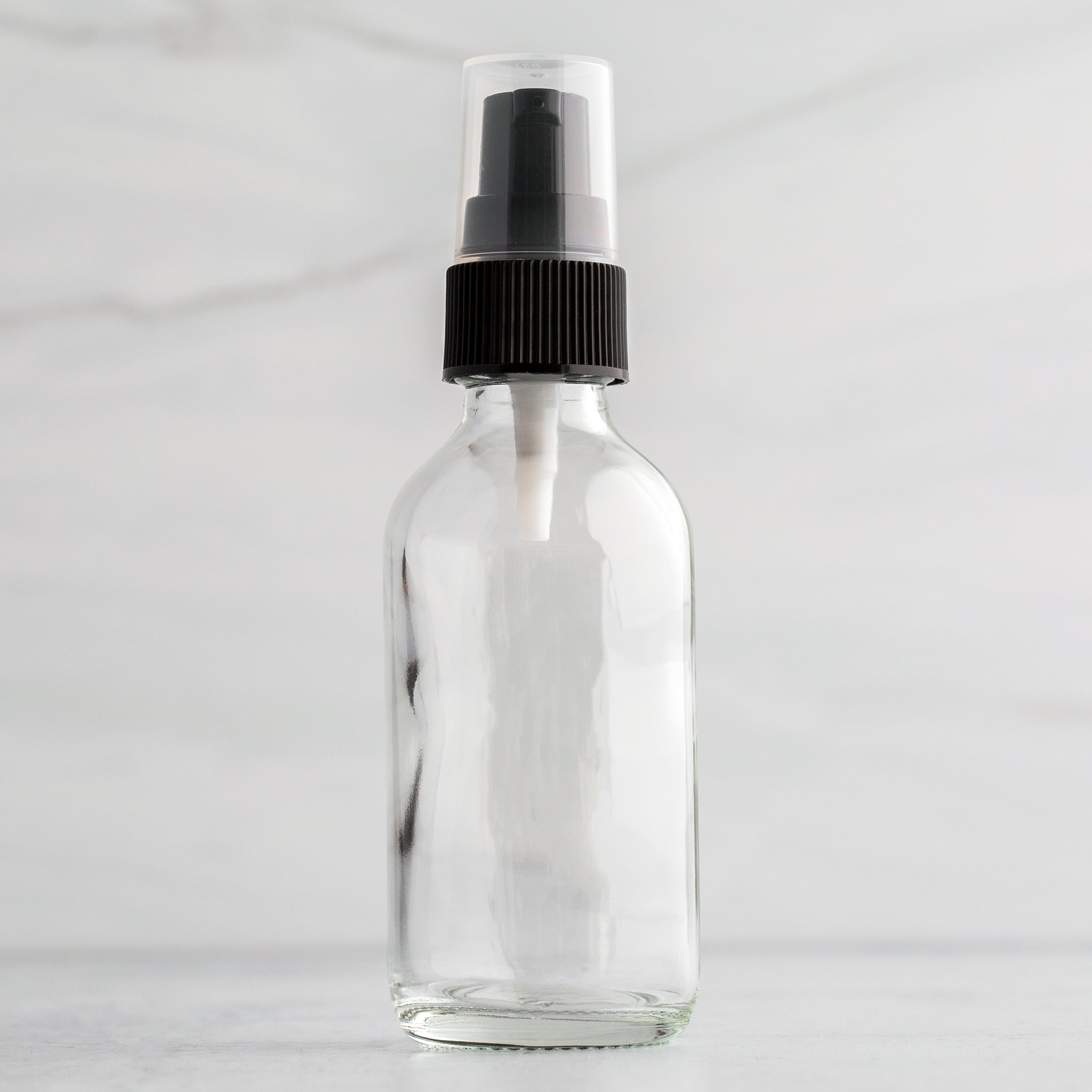 2 oz Clear Glass Bottle with Black Treatment Pump