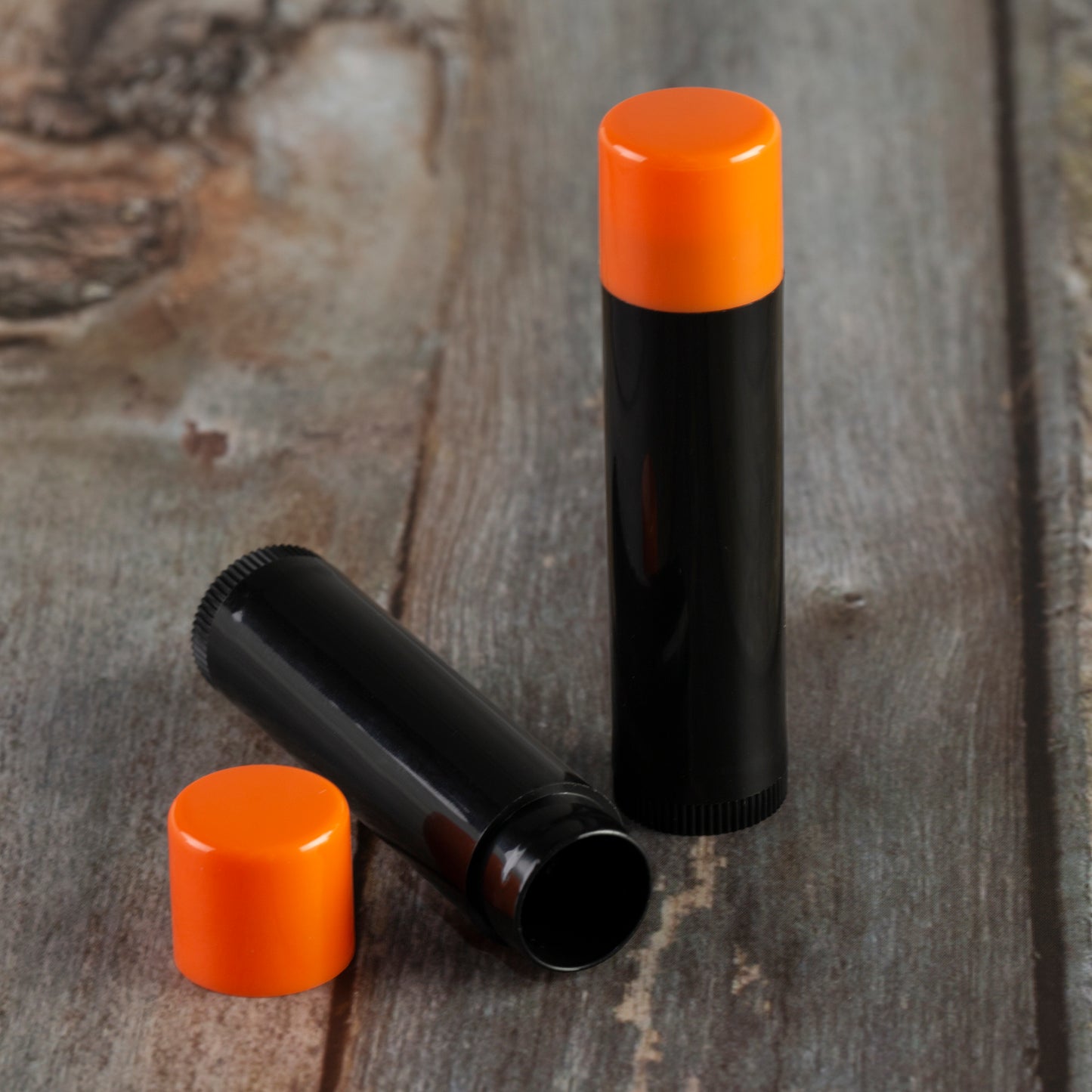 black lip balm tube orange cap